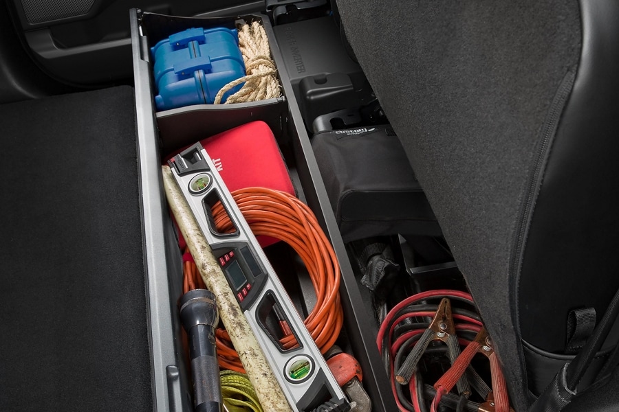 Gros plan d’équipement entreposé dans les boîtes de rangement sous le siège