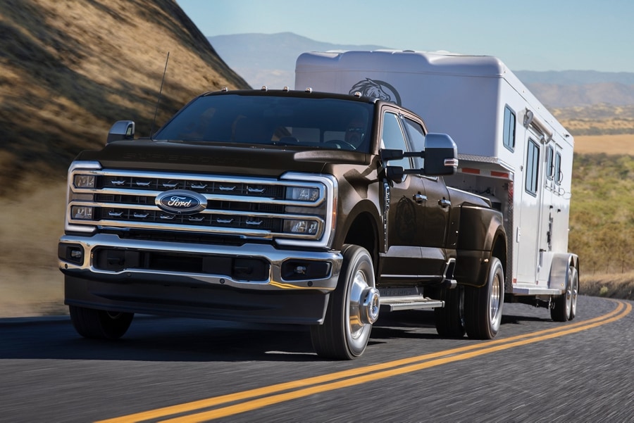 Modèle Ford Super Duty® F-350® LARIAT® 2025 en bronze foncé métallique tirant une remorque à cheval