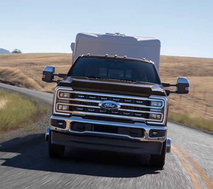 Vue avant d’un camion Ford Super Duty® F-350® LARIAT® 2025 tirant une remorque