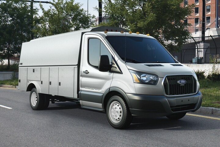 Un Ford Transit® 2023 conduit sur une route dans un environnement urbain
