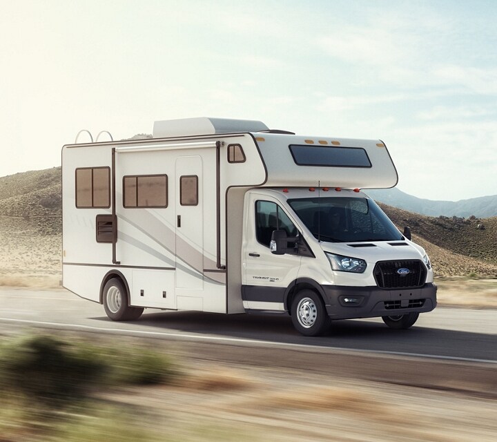 Modèle tronqué Ford Transit® 2024 avec carrosserie d’autocaravane du marché secondaire circulant sur une autoroute