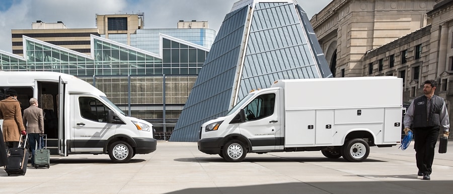 Des personnes près d’un modèle Ford Transit® 2025 avec carrosserie-navette et Ford Transit® 2025 avec carrosserie utilitaire de marché secondaire