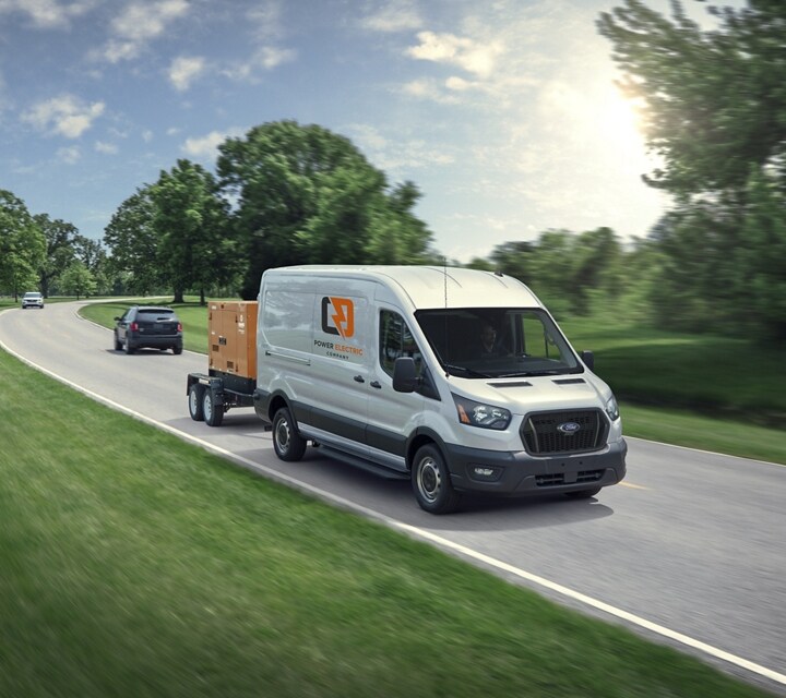 Une fourgonnette Ford Transit® 2024 tirant une remorque sur une route de campagne