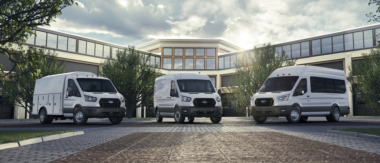 Trois fourgonnettes Ford Transit® 2025 stationnées à l’extérieur d’un immeuble de bureaux
