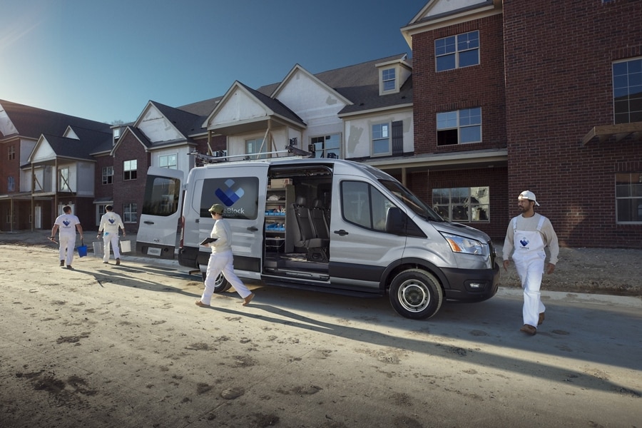 Une fourgonnette Ford Transit® 2025 sur un chantier avec portes coulissantes et arrière ouvertes