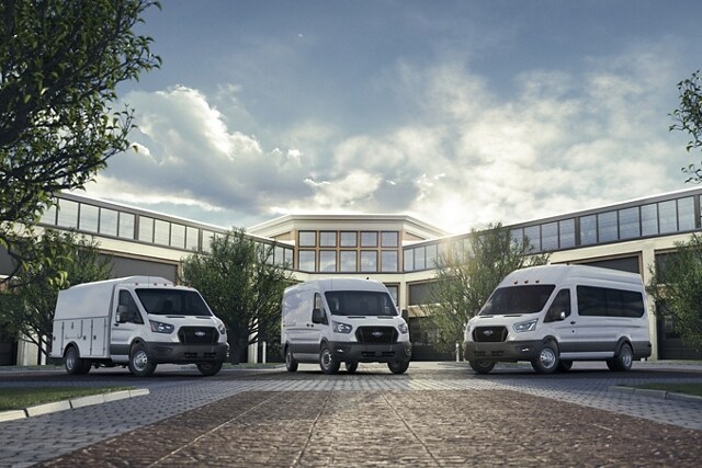 Trois véhicules Ford Transit® 2023 stationnés devant un bâtiment