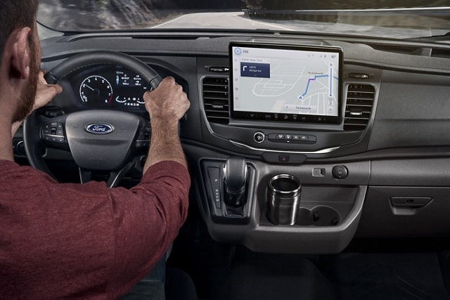 Personne conduisant un modèle Ford Transit® 2025 avec SYNC® 4 et écran utilitaire de 12 po en option